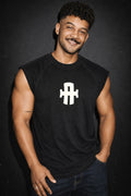 Man wearing a black sleeveless shirt with a white logo on a dark background
