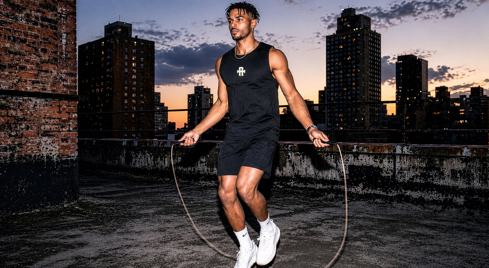 Man skipping rope on a rooftop with city skyline in the background