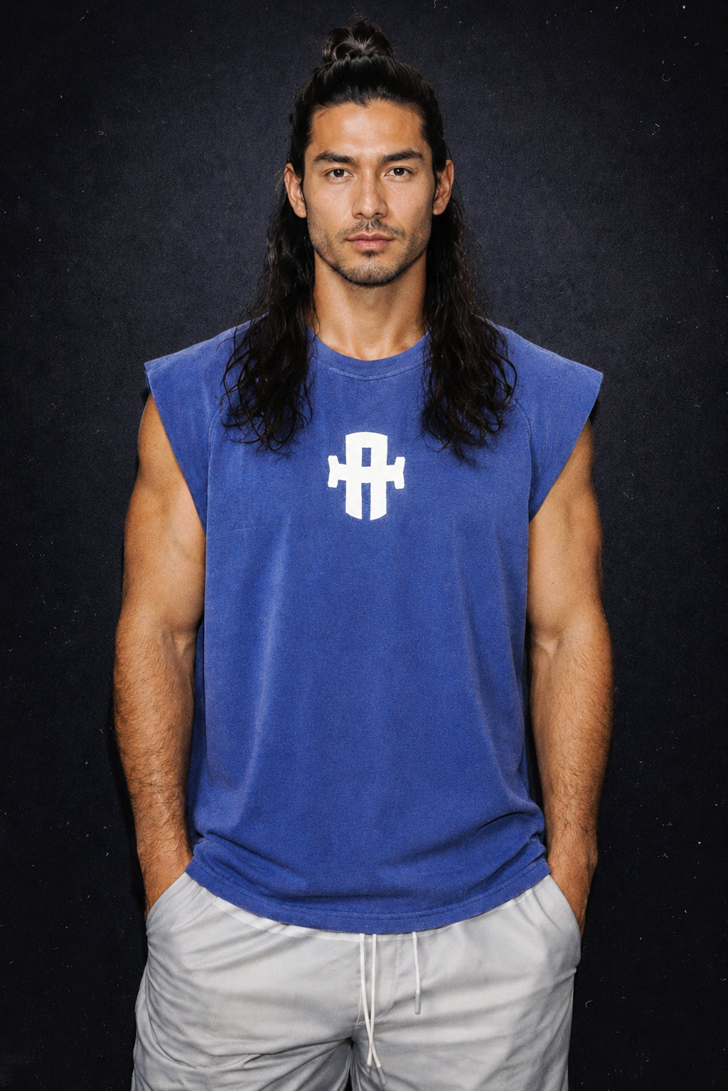 Man wearing a blue sleeveless shirt with a logo on a black background