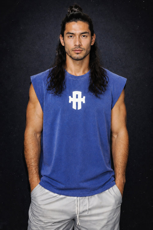 Man wearing a blue sleeveless shirt with a logo on a black background