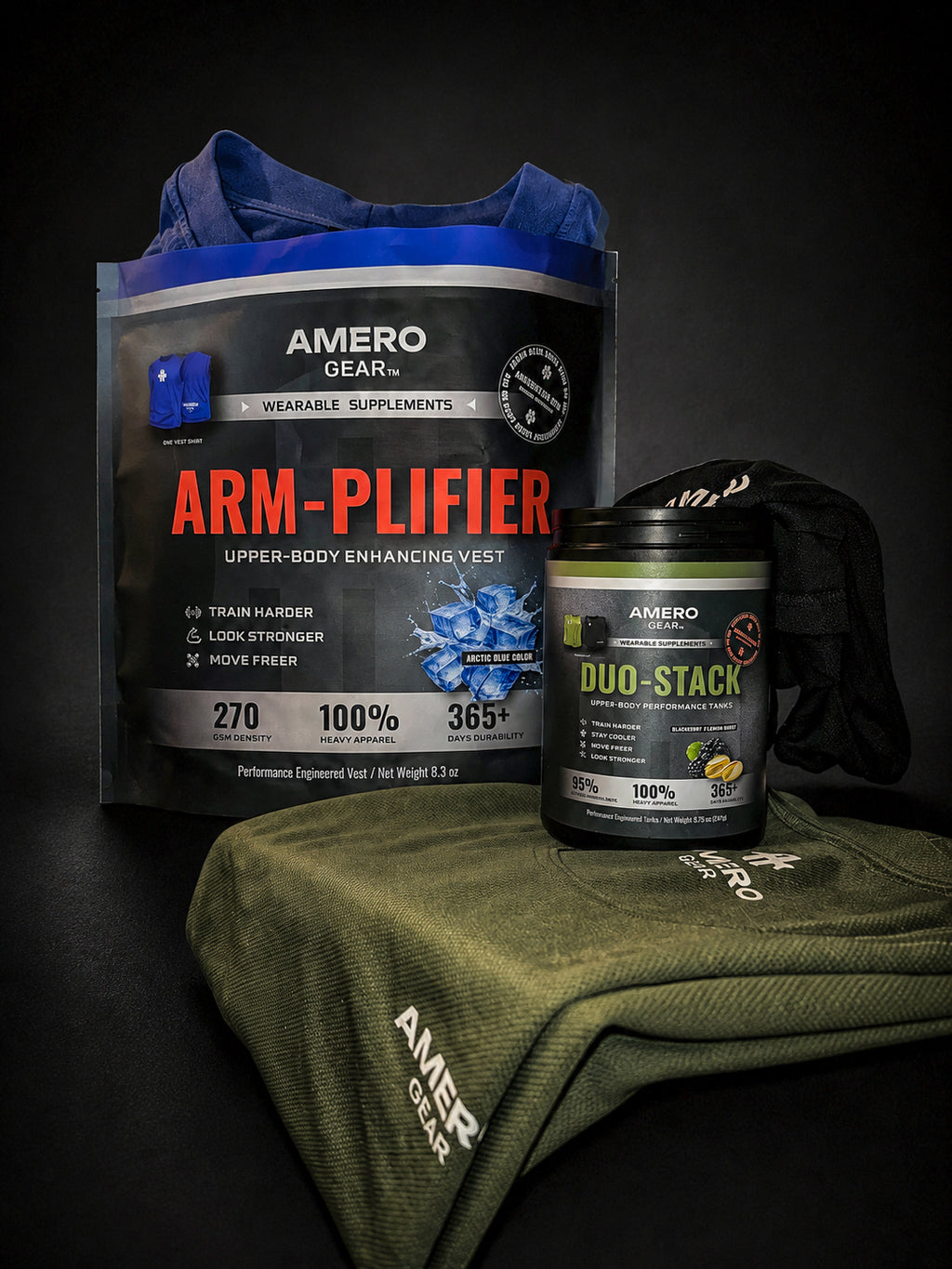 A product bundle from Amero Gear on a dark studio background, featuring a blue and black 'Arm-Plifier' wearable supplement pouch, a black 'Duo-Stack' powder tub, and an olive green branded sweatshirt draped over a dark surface.