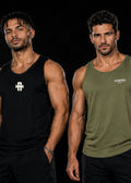 Two men modeling athletic tank tops and shorts on a black studio background. The man on the left wears a black sleeveless tank top with a white geometric logo and black shorts.