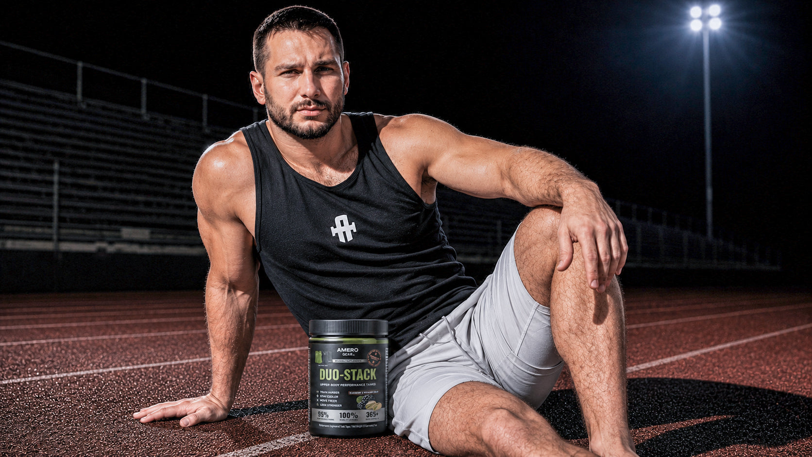 Muscular man sitting on a track with a supplement container labeled 'Doo Stack' in front of him.