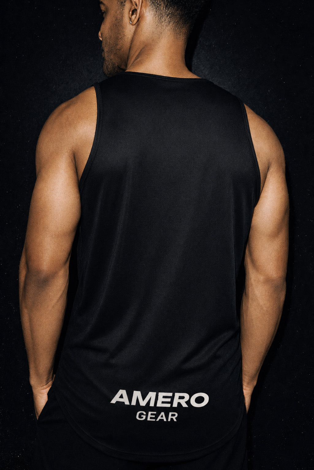 Person wearing a black tank top with 'Amero Gear' branding on a black background